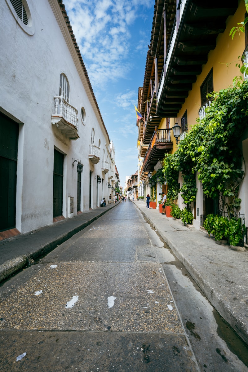 A narrow cobblestone street lined with colorful buildings.